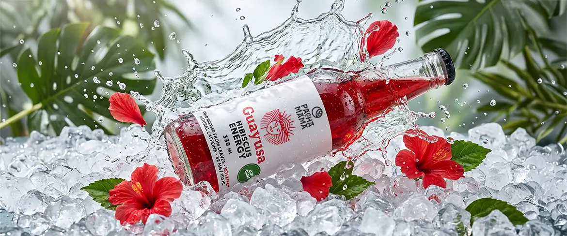 Μπουκάλι Guayusa Pachamama Cold Brew σε θρυμματισμένο πάγο με άνθη ιβίσκου.